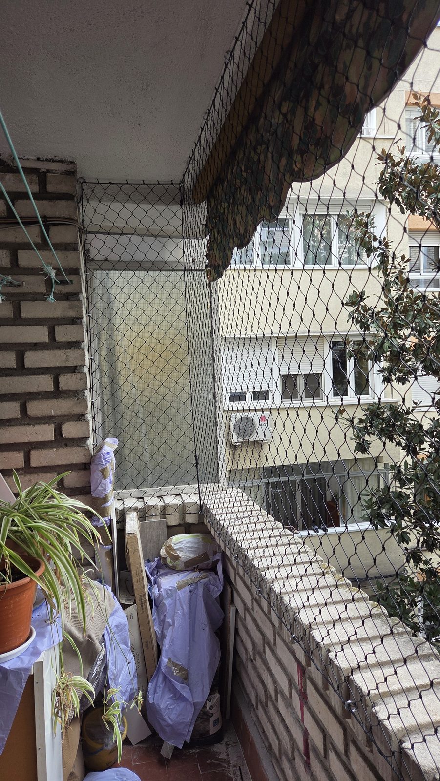 Balcón de ladrillo visto con red de protección