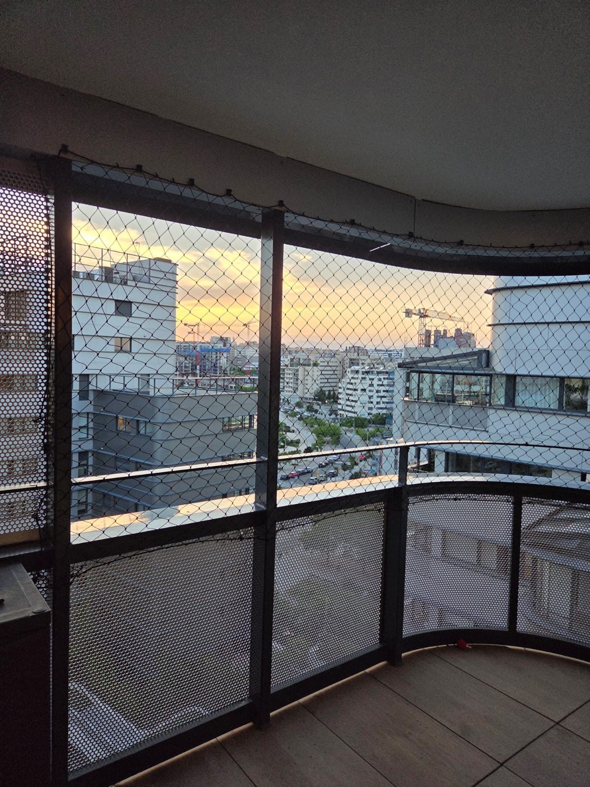 Balcón acristalado con red de protección al atardecer