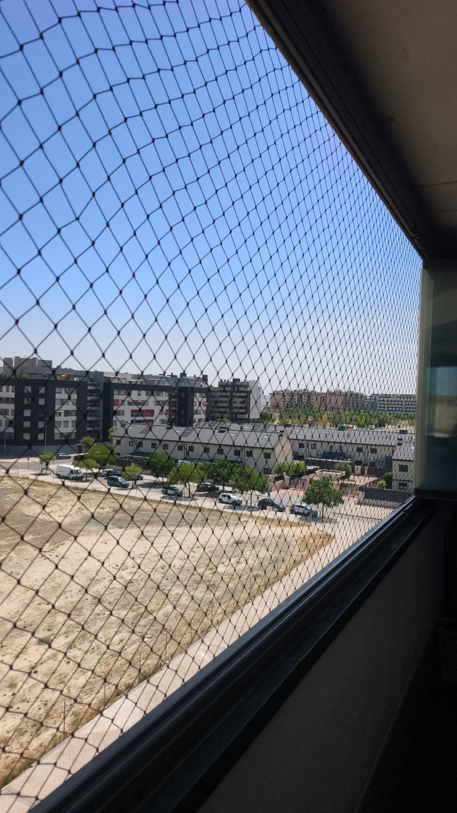 Ventanal con red de protección y vistas a la ciudad
