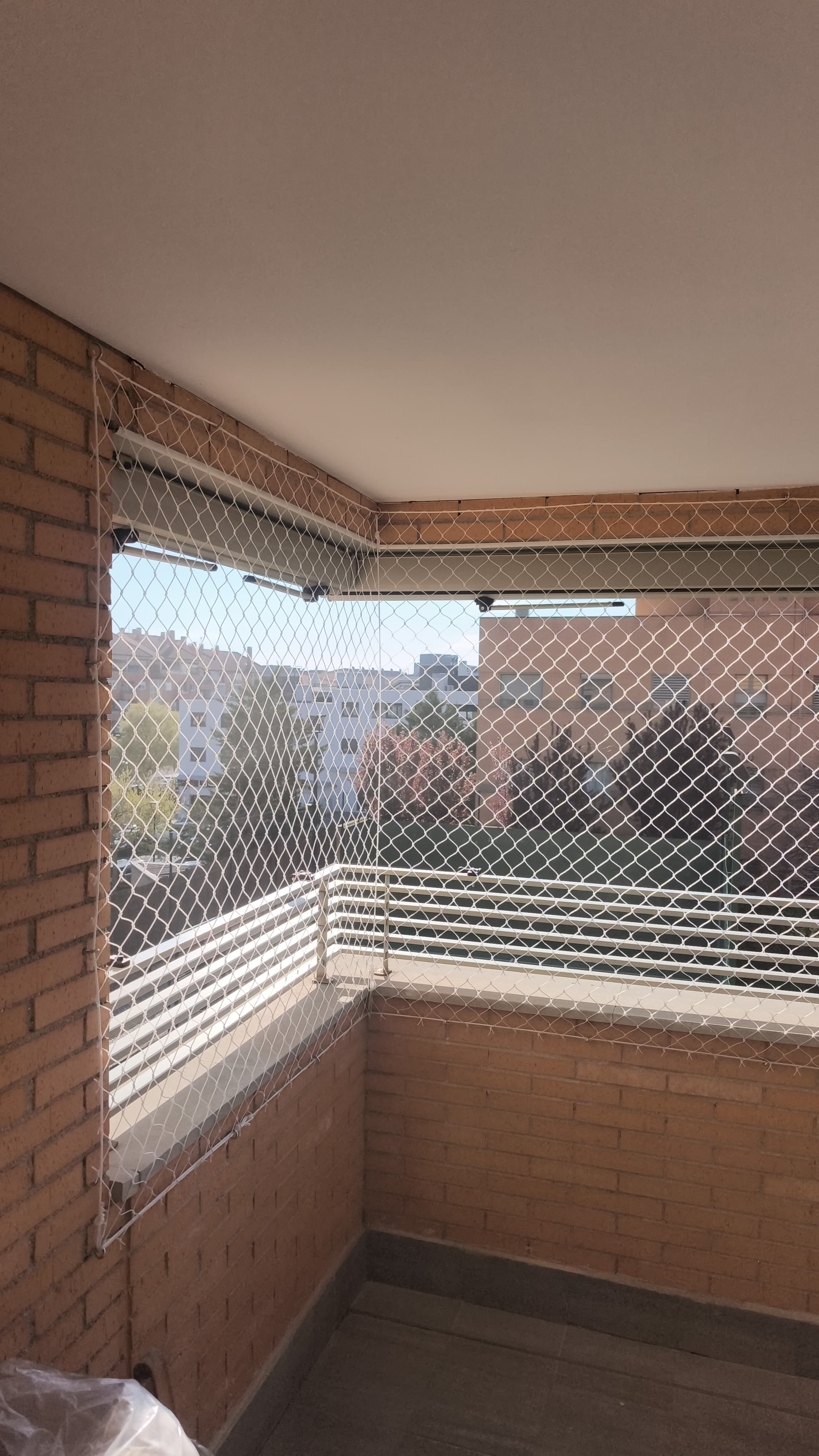 Rincón de balcón cubierto con red de seguridad